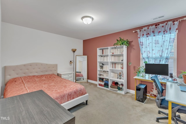 bedroom with an office area, carpet, and baseboards