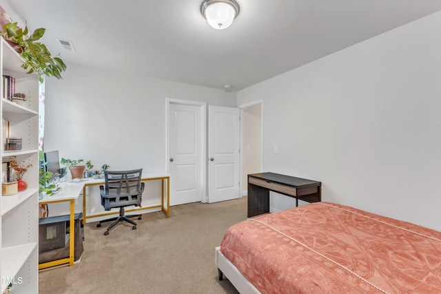 carpeted bedroom featuring a desk