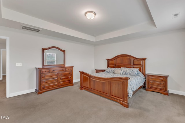 bedroom featuring carpet, baseboards, and a tray ceiling