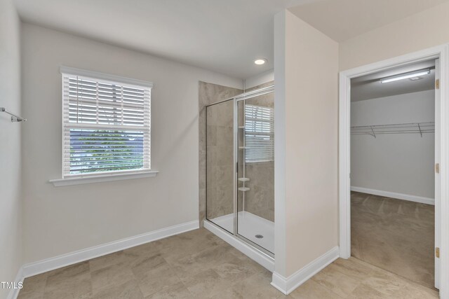 full bathroom featuring a stall shower, baseboards, plenty of natural light, a spacious closet, and recessed lighting