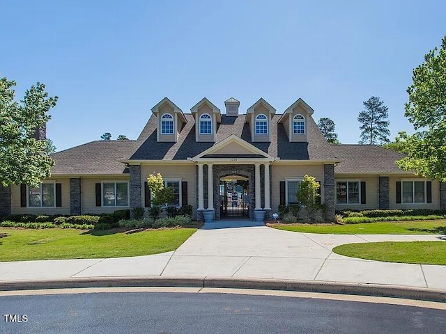 view of front of house with a front lawn and curved driveway