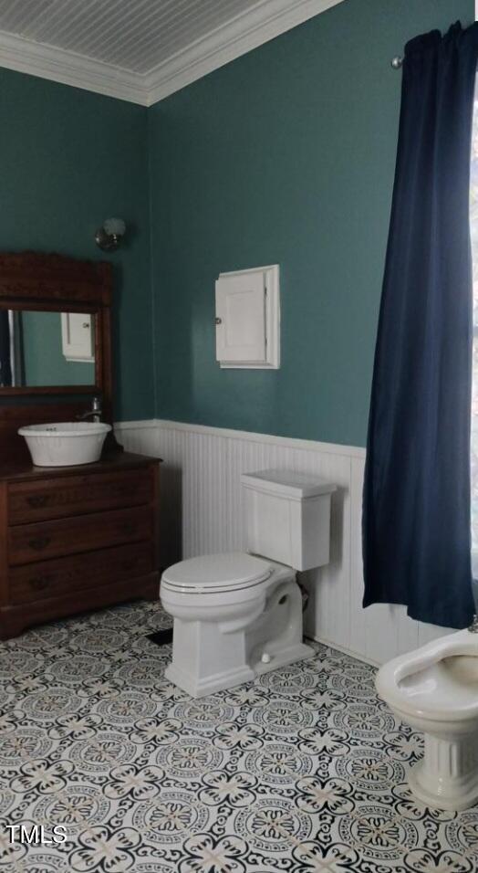 417 S Main St, Warrenton, NC 27589 - half bathroom with toilet, a wainscoted wall, crown molding, tile patterned floors, and vanity