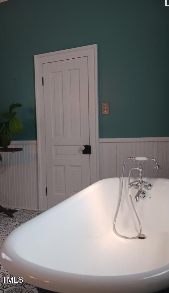 417 S Main St, Warrenton, NC 27589 - bathroom featuring wainscoting and a freestanding bath