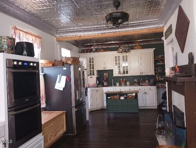 417 S Main St, Warrenton, NC 27589 - kitchen featuring stainless steel appliances, an ornate ceiling, white cabinetry, dark wood-type flooring, and glass insert cabinets