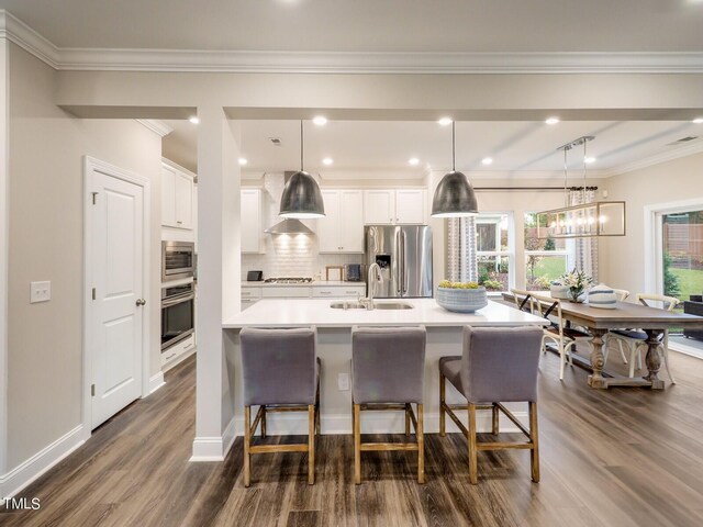 265 Sutherland Dr, Franklinton, NC 27525 - kitchen with stainless steel appliances, a sink, dark wood finished floors, a breakfast bar, and light countertops
