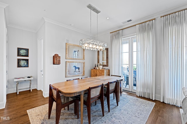 620 Wade Ave Unit 505, Raleigh, NC 27605 - dining room featuring wood finished floors, crown molding, baseboards, and a chandelier