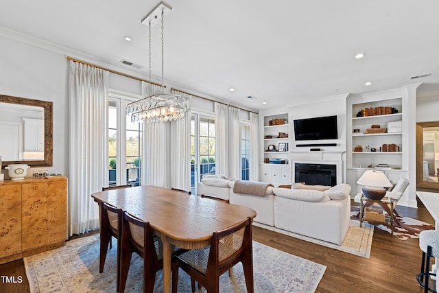 620 Wade Ave Unit 505, Raleigh, NC 27605 - dining room featuring ornamental molding, a fireplace, a chandelier, wood finished floors, and recessed lighting