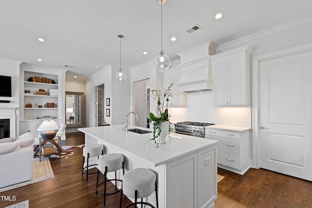 620 Wade Ave Unit 505, Raleigh, NC 27605 - kitchen with a sink, high end range, open floor plan, ornamental molding, and an island with sink