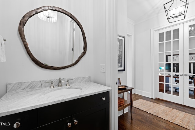620 Wade Ave Unit 505, Raleigh, NC 27605 - bathroom with a chandelier, wood finished floors, vanity, and crown molding