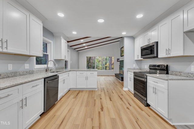 2600 Wade Ave, Raleigh, NC 27607 - kitchen featuring stainless steel appliances, a sink, a peninsula, light wood-style floors, and white cabinets