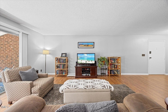 4709 Edwards Mill Rd Unit H, Raleigh, NC 27612 - living room featuring wood finished floors, a textured ceiling, and baseboards