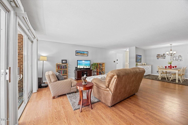 4709 Edwards Mill Rd Unit H, Raleigh, NC 27612 - living area featuring light wood-style floors, a chandelier, and a textured ceiling