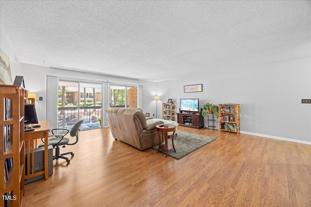 4709 Edwards Mill Rd Unit H, Raleigh, NC 27612 - living room featuring a textured ceiling, an office area, and wood finished floors