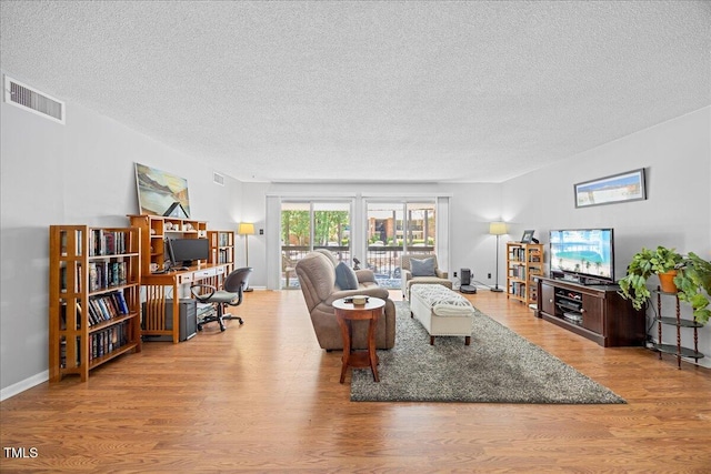 4709 Edwards Mill Rd Unit H, Raleigh, NC 27612 - living area featuring a textured ceiling, wood finished floors, and a desk
