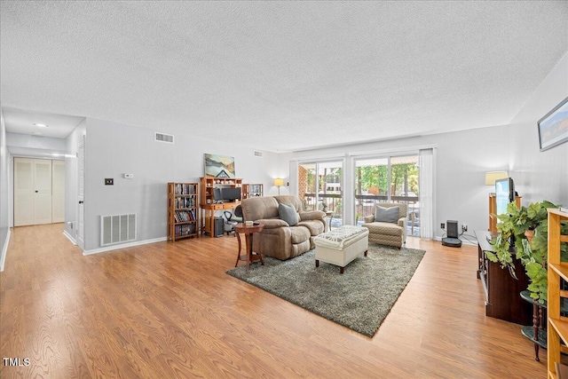 4709 Edwards Mill Rd Unit H, Raleigh, NC 27612 - living area with a textured ceiling, wood finished floors, and baseboards