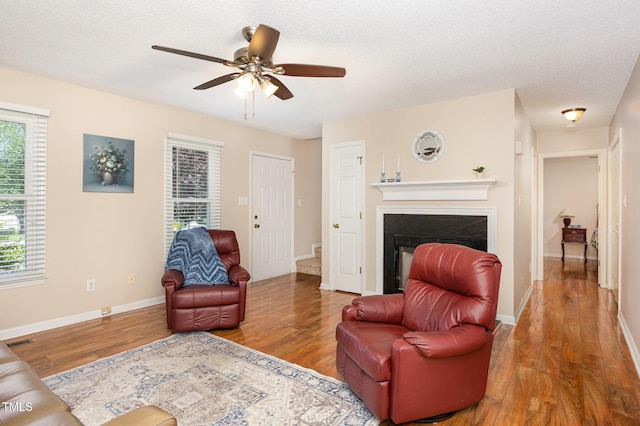 809 Maple Shade Ln, Apex, NC 27502 - living room featuring wood finished floors, ceiling fan, a glass covered fireplace, and baseboards