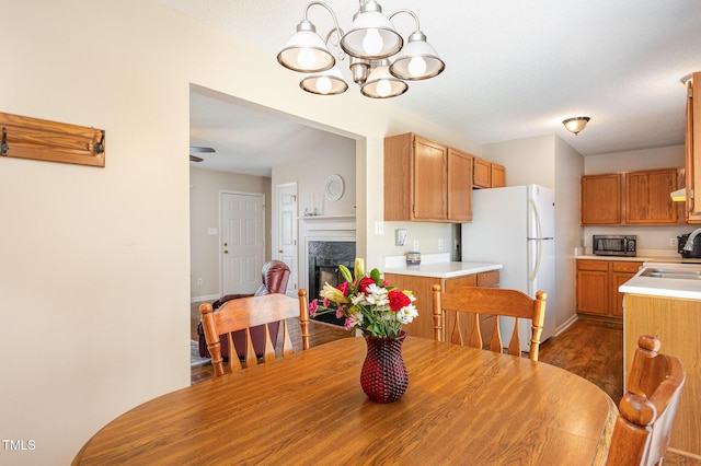 809 Maple Shade Ln, Apex, NC 27502 - dining space with a chandelier, a fireplace, dark wood finished floors, and baseboards