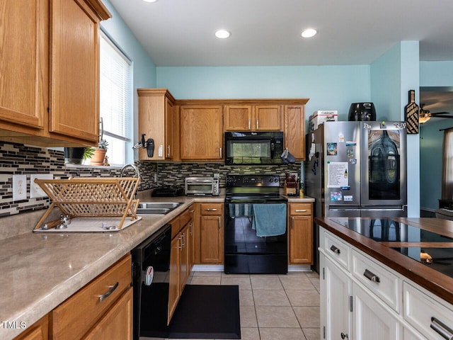 3507 Portico Ln, Durham, NC 27703 - kitchen featuring black appliances, tasteful backsplash, light tile patterned flooring, brown cabinetry, and recessed lighting