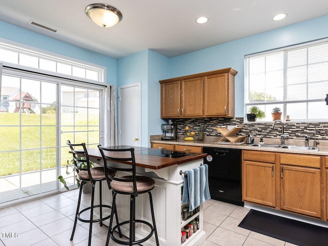 3507 Portico Ln, Durham, NC 27703 - kitchen featuring a sink, black dishwasher, light tile patterned flooring, backsplash, and brown cabinets