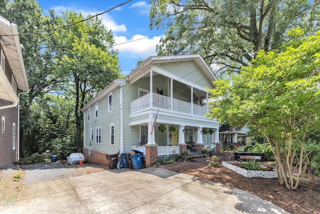 view of front of home with a balcony, a porch, and driveway