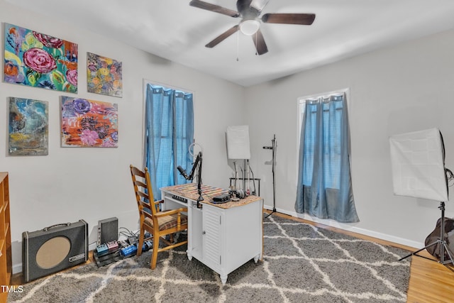 home office featuring ceiling fan, wood finished floors, and baseboards
