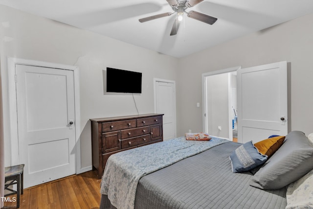 bedroom with hardwood / wood-style floors, ceiling fan, and baseboards