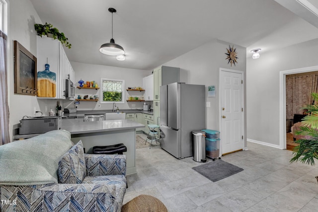 kitchen with stainless steel appliances, open shelves, a sink, a peninsula, and light countertops