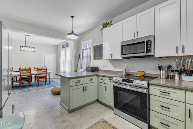 kitchen featuring appliances with stainless steel finishes, a peninsula, green cabinets, hanging light fixtures, and white cabinets