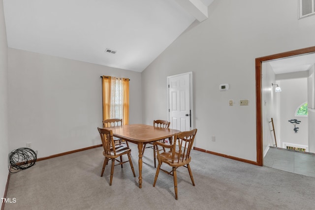 dining space featuring light colored carpet, high vaulted ceiling, baseboards, beamed ceiling, and plenty of natural light