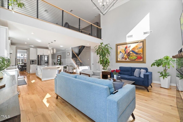 204 Woodstaff Ave, Wake Forest, NC 27587 - living room featuring stairs, a towering ceiling, light wood-style flooring, crown molding, and recessed lighting