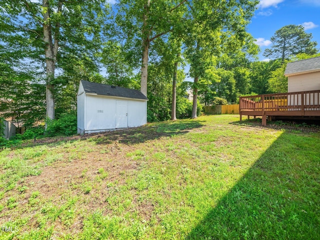 view of yard with a storage unit, a deck, and an outbuilding