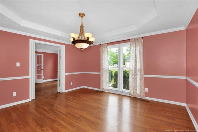5704 Kindley Dr, Fayetteville, NC 28311 - spare room featuring a raised ceiling, wood finished floors, a chandelier, and crown molding