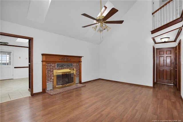 5704 Kindley Dr, Fayetteville, NC 28311 - unfurnished living room with high vaulted ceiling, ceiling fan, wood finished floors, baseboards, and a fireplace