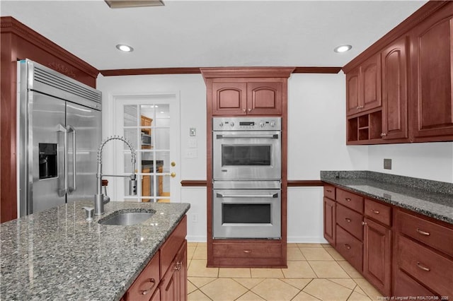 5704 Kindley Dr, Fayetteville, NC 28311 - kitchen with appliances with stainless steel finishes, a sink, dark stone counters, crown molding, and light tile patterned floors