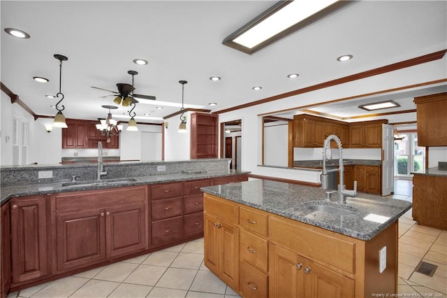 5704 Kindley Dr, Fayetteville, NC 28311 - kitchen with a sink, crown molding, light tile patterned floors, a kitchen island with sink, and dark stone counters
