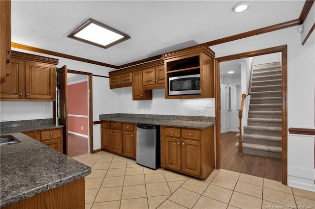 5704 Kindley Dr, Fayetteville, NC 28311 - kitchen featuring stainless steel microwave, light tile patterned floors, crown molding, brown cabinets, and recessed lighting