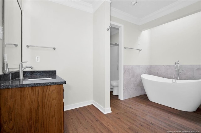 5704 Kindley Dr, Fayetteville, NC 28311 - bathroom with tile walls, wood finished floors, ornamental molding, a freestanding tub, and vanity