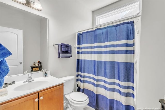bathroom with toilet, vanity, and curtained shower