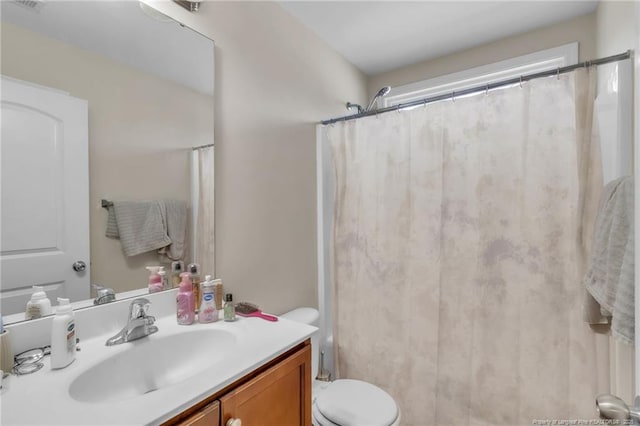 bathroom with vanity, toilet, and curtained shower