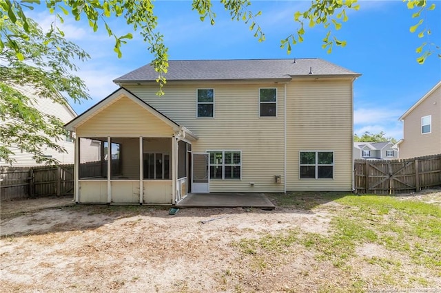 back of property featuring a sunroom, a patio area, and a fenced backyard
