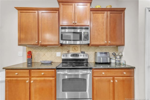 1504 Laguardia Dr, Hope Mills, NC 28348 - kitchen with stainless steel appliances, backsplash, and dark stone countertops