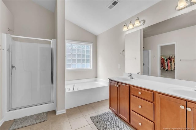 1504 Laguardia Dr, Hope Mills, NC 28348 - bathroom featuring a stall shower, vaulted ceiling, a bath, double vanity, and a spacious closet