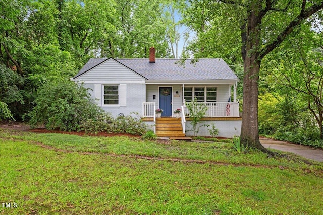 2324 Stevens Rd, Raleigh, NC 27610 - view of front of house featuring a porch, a chimney, a front yard, and roof with shingles