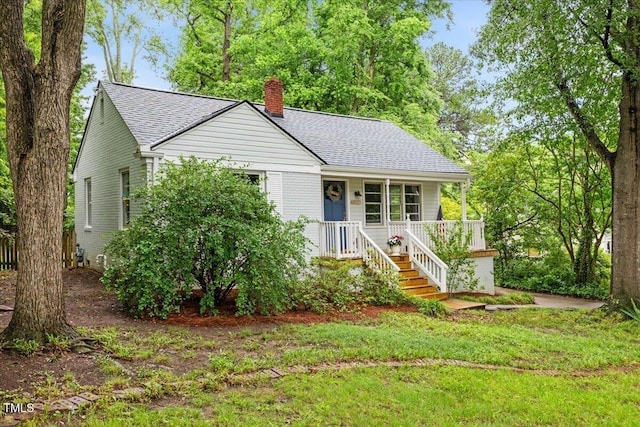 2324 Stevens Rd, Raleigh, NC 27610 - view of front of home with a chimney, a shingled roof, covered porch, and a front lawn