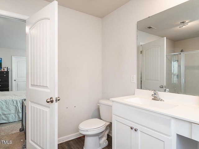 full bathroom with toilet, a shower with door, vanity, connected bathroom, and baseboards