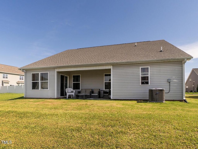 rear view of property with outdoor lounge area, a lawn, and central AC