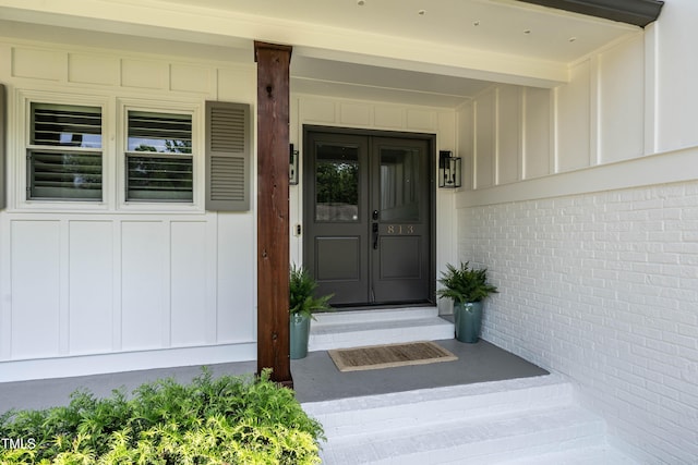 entrance to property with board and batten siding and brick siding
