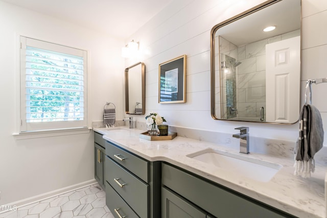 bathroom featuring a stall shower, double vanity, baseboards, and tile patterned flooring