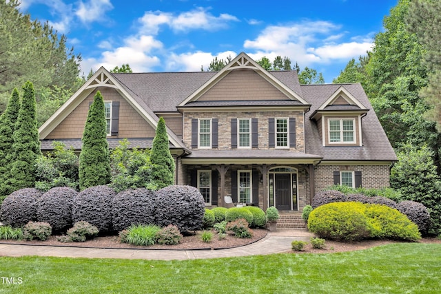 3007 Krogen Ct, Creedmoor, NC 27522 - craftsman-style home featuring a front lawn, covered porch, stone siding, and roof with shingles