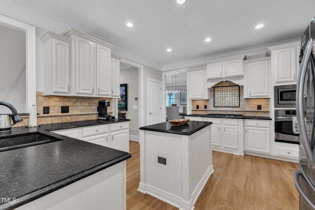 3007 Krogen Ct, Creedmoor, NC 27522 - kitchen featuring stainless steel appliances, a sink, light wood-style flooring, a center island, and white cabinets